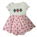 Custom twirl dress flat lay showing white bodice with strawberry applique and pink polka dot skirt